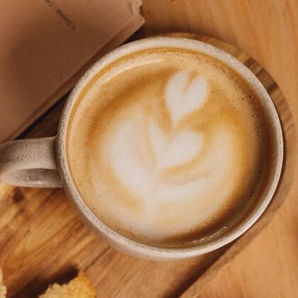Capuchino con roseta sobre una tabla de madera