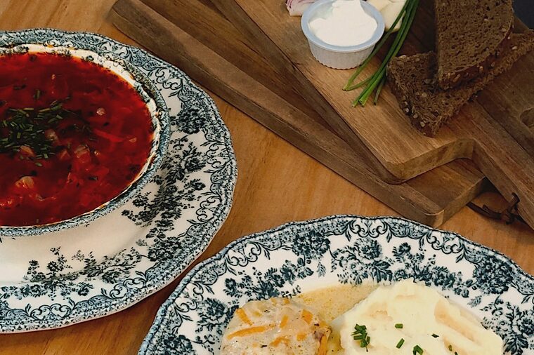 Borsch con salo y pan negro junto a albóndigas en salsa cremosa con puré, en loza azul